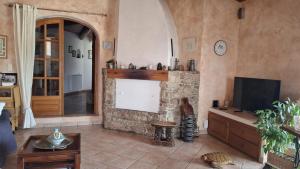 a living room with a stone fireplace and a tv at Maison Cistaredda in Sotta