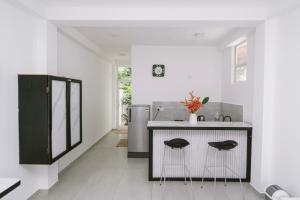 a white kitchen with a sink and a counter at Vega Haven in Matara