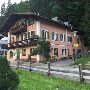 een roze huis met een hek ervoor bij Haus Stainer in Lofer