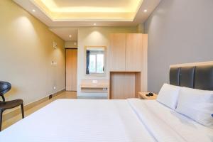 a bedroom with a large white bed and a desk at J P Guest House in Howrah