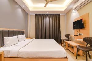 a bedroom with a bed and a desk and a television at J P Guest House in Howrah