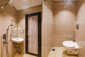 a bathroom with a toilet and a shower and a sink at J P Guest House in Howrah