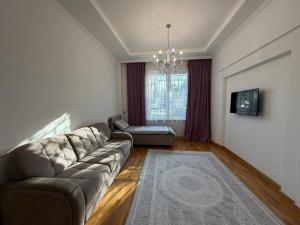a living room with a couch and a television at HomeLand in Almaty