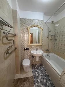 a bathroom with a sink and a toilet and a bath tub at HomeLand in Almaty