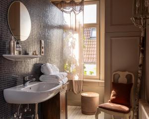 a bathroom with a sink and a mirror and a window at Guesthouse Nights by Morpheus in Antwerp