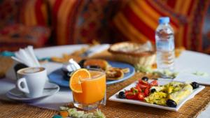 a table with a plate of food and a glass of orange juice at Le Lagon Bleu Oualidia in Oualidia +17 photos