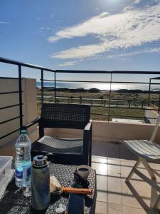 a balcony with a chair and a table and a water bottle at la vue coucher de soleil in Hauara