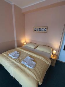 a bedroom with a large bed with towels on it at Hotel Koruna in Roudnice nad Labem