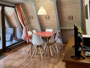 a dining room with a red table and white chairs at Ferienhaus Hasenglück in Waldbrunn