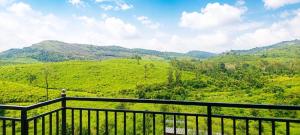 a balcony with a view of a green mountain at Kalathil Guest House in Vagamon