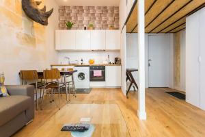 a kitchen and living room with a couch and a table at Appartement quartier St Michel climatisé près des quais avec parking in Bordeaux