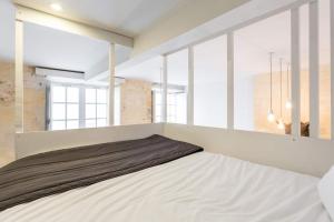 a large bed in a room with windows at Appartement quartier St Michel climatisé près des quais avec parking in Bordeaux