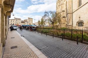 a group of people riding horses down a city street at Appartement quartier St Michel climatisé près des quais avec parking in Bordeaux