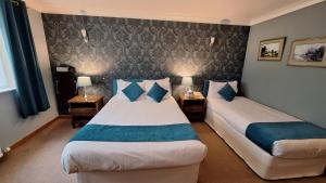 a hotel room with two beds and two lamps at Mansfield Castle Hotel in Tain