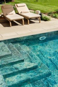 two chairs sitting next to a swimming pool at Nus Hotel Poerio in Rome