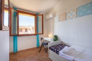 a bedroom with a bed and a desk and a window at Domu Margarida in Chia