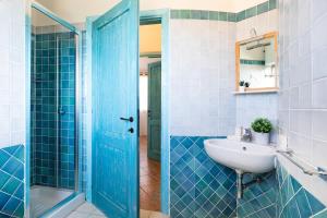 a blue bathroom with a sink and a shower at Domu Margarida in Chia