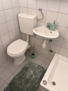 a white bathroom with a toilet and a sink at Apartman Amal in Vukovar +37 photos