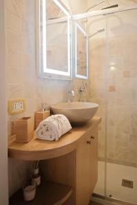 a bathroom with a sink and a glass shower at Dimora Le Volte Ostuni in Ostuni