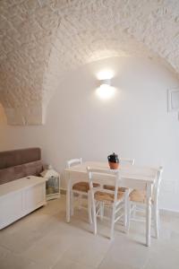 a white dining room with a white table and chairs at Dimora Le Volte Ostuni in Ostuni +9 photos