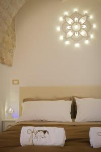 a bedroom with a bed with a chandelier on the wall at Dimora Le Volte Ostuni in Ostuni