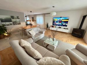 a living room with a couch and a table and a tv at Villa Silente in Oklaj