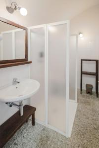 a white bathroom with a sink and a mirror at Casa Vanni Dimora storica in Camblione