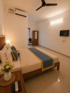 a bedroom with a large bed and a table at Uthram Avenue in Tāmarakulam