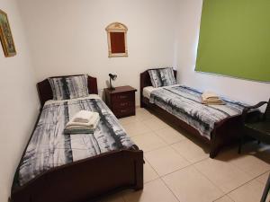 a bedroom with two beds and a green board at HomeSweetHome in Paphos