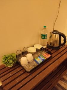 a tray with dishes and a tea kettle on a table at Mahadev Bhavan in Chittaurgarh