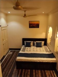 a bedroom with a large bed with blue pillows at Mahadev Bhavan in Chittaurgarh
