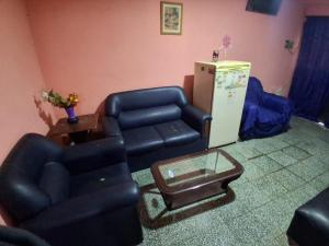 a living room with two chairs and a refrigerator at Casa Chicho in Santiago del Estero +3 photos