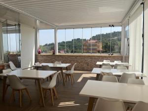 eine Cafeteria mit Tischen und Stühlen und großen Fenstern in der Unterkunft La Terrazza in Cotronei