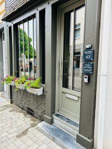 a door of a store with flowers in windows at Chez Gaston in Spa