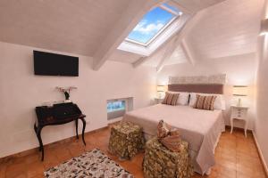 a bedroom with a bed and a desk and a window at Odisseo Apartments in Minori +23 photos