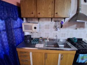 a kitchen with a sink and a microwave at Casa Chicho in Santiago del Estero