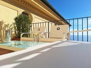 a balcony with two chairs and a table with wine glasses at Odisseo Apartments in Minori