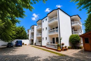 a white apartment building with a parking lot at Hotel Bar Restaurant MANI in Velipojë