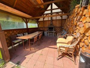 a patio with a table and chairs and a stone wall at Apart-Bungalovy Gitka in Mlynčeky