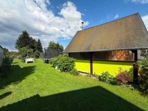 a yellow building with a roof on a yard at Apart-Bungalovy Gitka in Mlynčeky