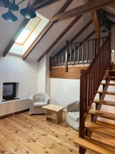 a living room with a staircase and a tv at Ohaba 140-141 By Holztreppe in Ohaba