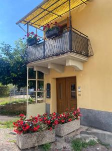 a building with a balcony with flowers on it at Casa Marta in Lisignago +2 photos