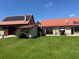 a house with solar panels on top of a yard at Ohaba 140-141 By Holztreppe in Ohaba