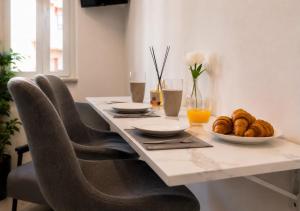 a table with chairs and a plate of food on it at Mellini Living in Misano Adriatico