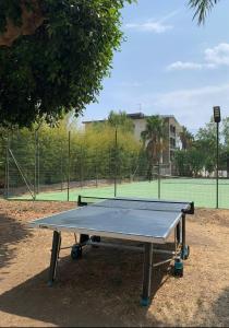 a ping pong table in front of a tennis court at Suli e Sali Apartment in Calatabiano