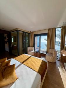 a bedroom with a large bed with a view of the ocean at Royal Room 5 Chambre Royale in Asilah