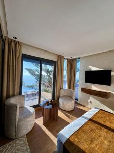 a hotel room with a bedroom with a view of the ocean at Royal Room 5 Chambre Royale in Asilah
