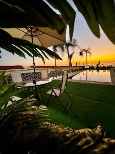 a table and chairs on the beach with the sunset at Royal Room 5 Chambre Royale in Asilah