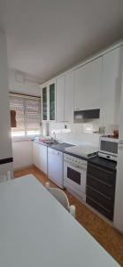 a kitchen with white cabinets and a stove top oven at Civico 22 Guest House in Pellaro