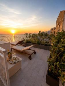 a sunset on a balcony with a view of the ocean at Vico Lungo 9, Peschici in Peschici